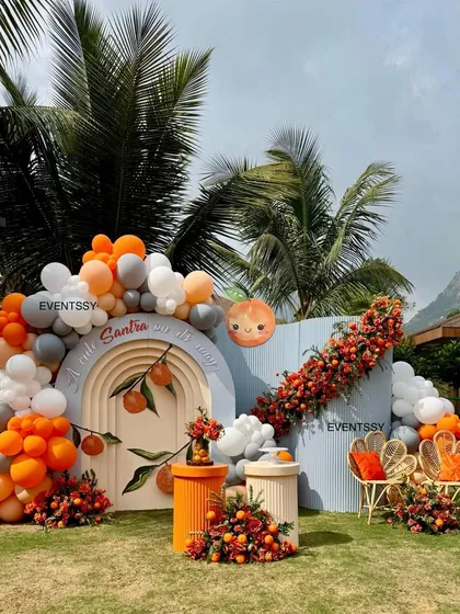 A look at my "Tangerine & Twinkles" baby shower theme, where we used an arch backdrop, custom seating, and vibrant balloon garlands. I love incorporating unique elements like real santras into the floral arrangements for a fresh, memorable touch.