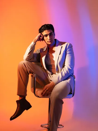 A full-body shot showing the modern styling. The makeup is subtle, ensuring the focus remains on the model and the clothes.