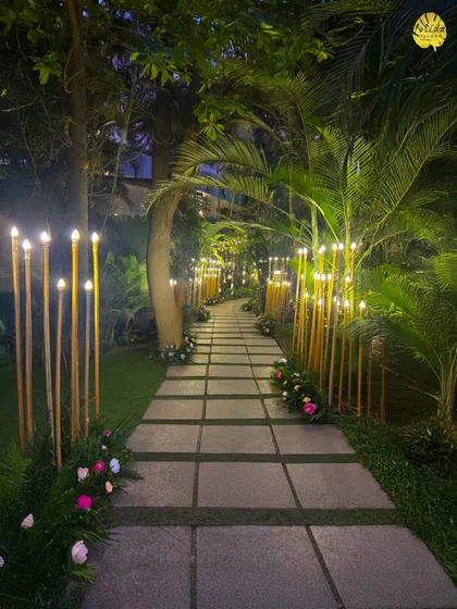 A beautifully lit garden path guides guests through the venue at night. The warm glow from the bamboo lights creates a welcoming and magical walkway.
