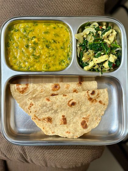 This plate features chapati with dal palak and a side of scrambled paneer with spinach, offering a delicious and protein-rich vegetarian option.