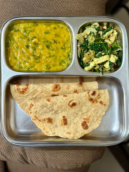 A plate with chapati, dal palak, and a paneer and spinach bhurji. This is a high-protein vegetarian meal that is rich in iron and other nutrients.