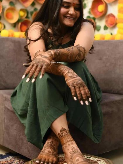 A candid shot of a happy client, showing her hand and foot mehendi.