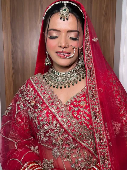 A full view of the bride's ceremony look. Her red lehenga, traditional jewelry, and my classic makeup artistry combine to create a picture of bridal perfection.