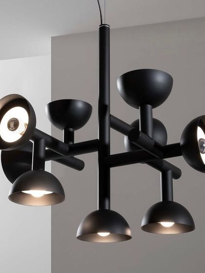 A close-up of the black Sibilla chandelier, highlighting the intersecting arms and the spherical caps that house the light sources.