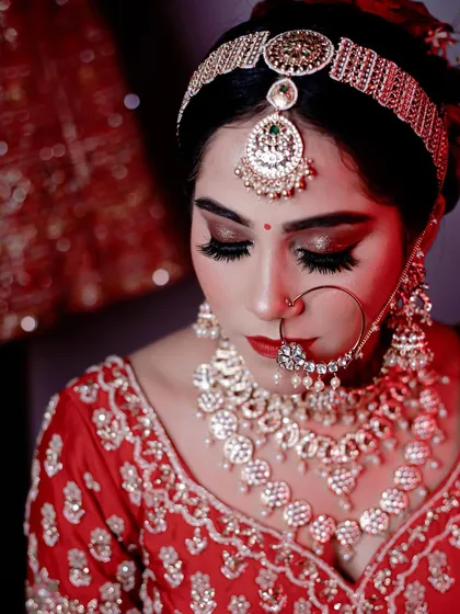 A close-up shot focusing on the intricate details of the eye makeup. I created a dramatic, winged liner and shimmery lids to make her eyes the star of the show, complementing her bold red bridal attire.