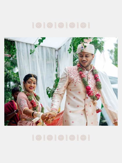 A beautifully framed photo of a couple during their wedding ceremony. This shot captures a happy, candid moment as they hold hands.