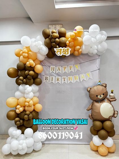 A cute and simple teddy bear theme for a first birthday. This decoration features a brown and white balloon arch and a large bear foil balloon, with a custom Marathi nameplate.