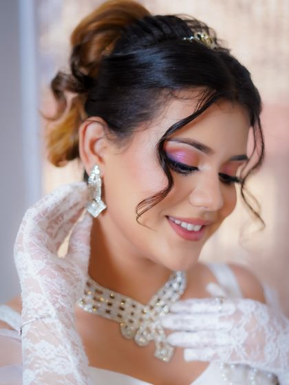 This close-up highlights the soft pink eyeshadow and the elegant, twisted updo.