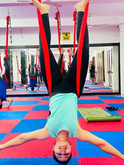 An inverted butterfly pose in the aerial hammock is both a great hip opener and a fun way to see the world from a new angle. This student smiles as she hangs effortlessly.