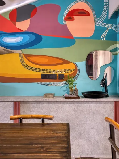 The mural interacting with a custom-shaped mirror, creating a playful dialogue between art and decor.