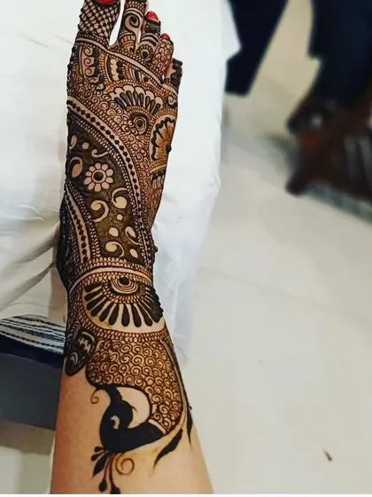 Bridal mehandi isn't just for hands. I create stunning, full-coverage designs for feet, like this one featuring a large peacock and intricate patterns that extend up the leg.