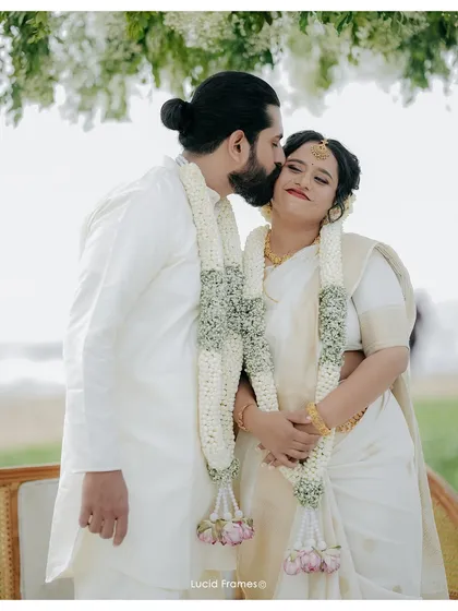 A sweet kiss on the cheek after the ceremony, with their jasmine garlands framing the shot beautifully.