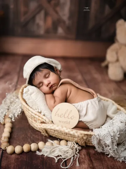 A newborn says "hello world" in this rustic, boho-themed setup. The natural textures and warm tones create a cozy and timeless feel for your baby's first portraits.