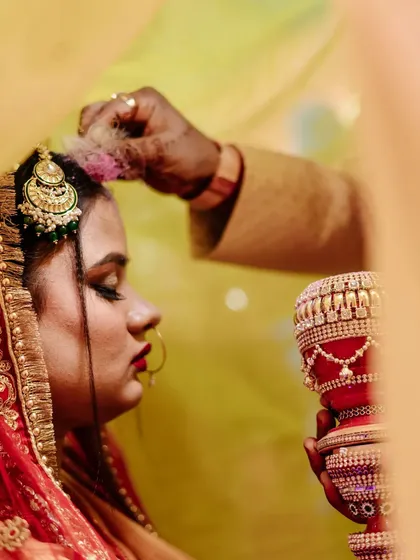 The Sindoor Daan is one of the most profound moments in an Indian wedding. I framed this shot to focus on the bride's reverent expression and the gentle application of the sindoor, capturing the solemnity and emotion of this sacred ritual.