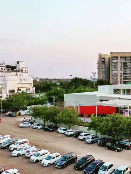 A view of the Glass Pavilion and its surroundings, including the organized parking area and adjacent buildings.