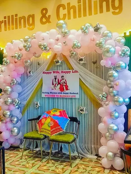 A lovely setup for a newly married couple, with a pink and silver balloon arch and a custom banner saying 'Happy Wife, Happy Life'.
