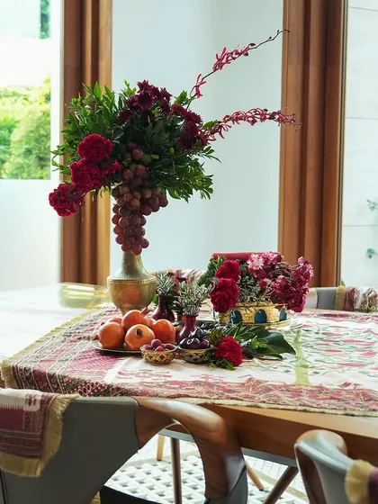 The indoor dining setup for 'दाड़म ka Bageecha'. The theme continues inside with a rich tablescape featuring floral arrangements, fresh fruits, and custom-designed table linens that echo the garden motif.
