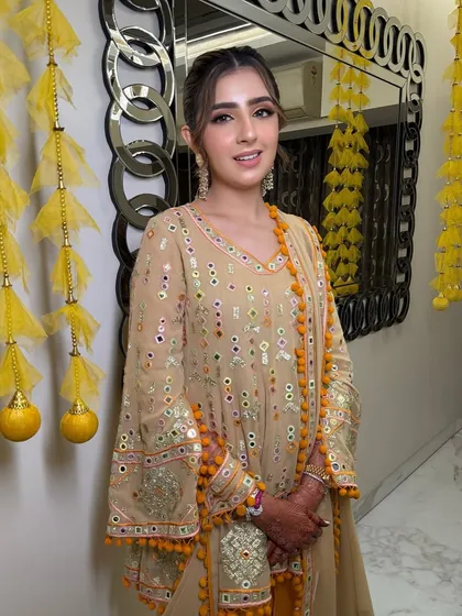 The client looks effortlessly chic in her traditional outfit, with a modern ponytail that adds a contemporary twist to her look.