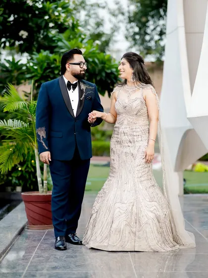 A classic, full-length couple portrait from an engagement shoot in a beautiful garden setting.