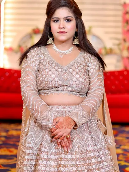A beautiful HD party makeup look. The client is wearing a beige lehenga with soft, neutral makeup.