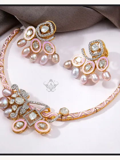 A unique and feminine necklace set featuring pink enamel, baroque pearls, and polki diamonds. The crescent-shaped necklace is a true statement of artistry and style.