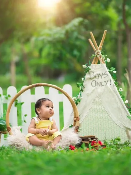 My outdoor sessions in Bangalore's beautiful green spaces offer a natural and light-filled backdrop. This boho-themed setup with a teepee and floral accents is perfect for sitter sessions and milestone photos.