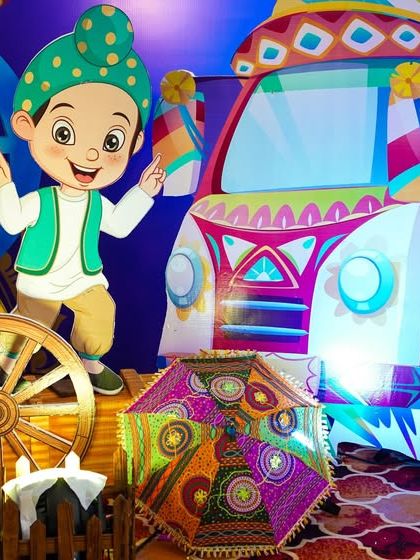 A close-up of the colorful truck prop and a cartoon character in traditional Punjabi dress.