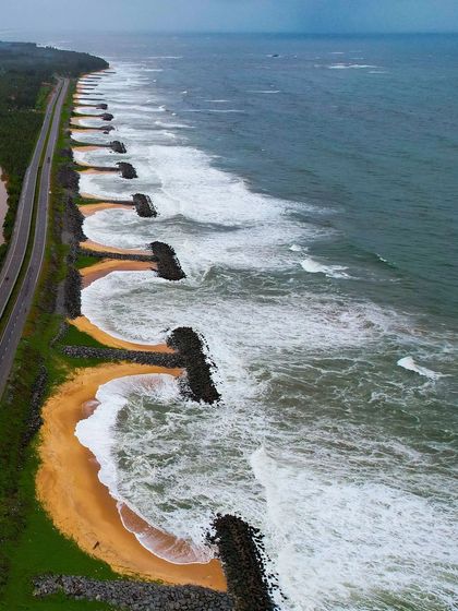 The beautiful curved sea walls at Maravanthe beach, creating small, protected coves.