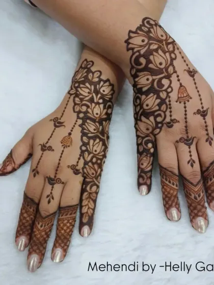 This design is a beautiful example of an Arabic-style vine. It flows diagonally across the hand, adorned with hanging bells and birds.