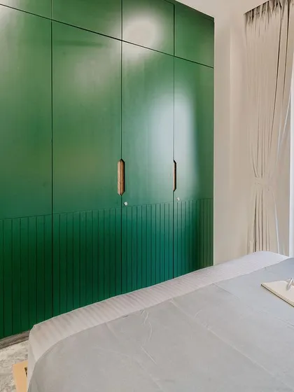 A view of the deep green wardrobes in the T7 T8 master bedroom, featuring concealed handles with a veneer inlay for a clean, minimal look.