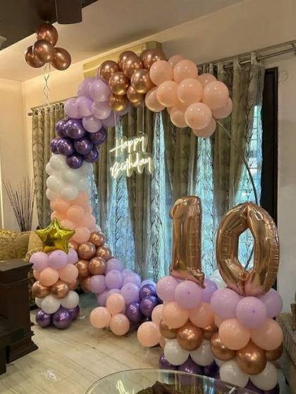 This angle highlights the number '10' balloon columns for the pastel-themed birthday.