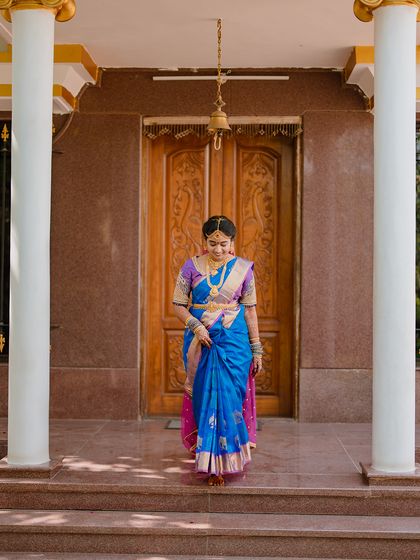 The bride's graceful entrance, framed by the traditional architecture of the venue, showcasing her elegance.