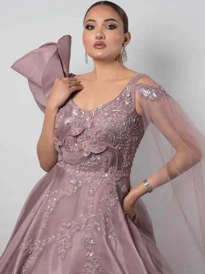 Dip into the elegance of pastel hues for your sangeet or engagement. This lavender gown features a dramatic one-shoulder bow and intricate silver embroidery, offering a modern and sophisticated look that is sure to turn heads.