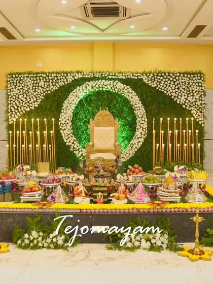 A specialized traditional plate decoration for a Half-Saree ceremony, with a green floral ring backdrop and elegant candle stands.