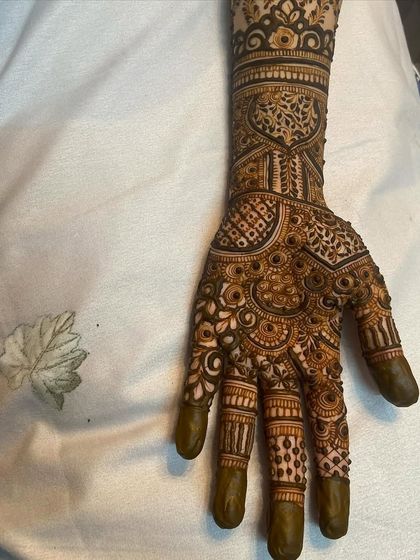 The back of one hand from the same bridal set, featuring a mix of checkerboard patterns and traditional motifs.