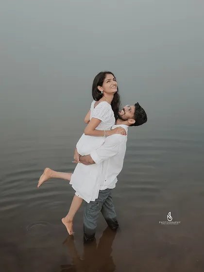 A joyful lift in the water, a perfect example of a fun and spontaneous moment during a pre-wedding shoot.