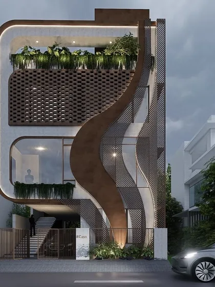 The facade of the Drape Residence in Bangalore is an exploration of organic form. A flowing, fabric-like element wraps around the structure, contrasting with the perforated brick screen and creating a home that is a piece of habitable sculpture.