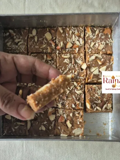 Holding a piece of Gur Papdi to show its crispy, crumbly texture. It's a delightful bite.