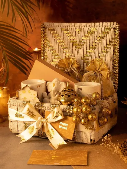 This stunning white and gold woven hamper is from our luxury Diwali collection. It’s filled with handpicked festive goodies like a Ganesha idol and premium sweets, designed to bring warmth and elegance to your celebrations.