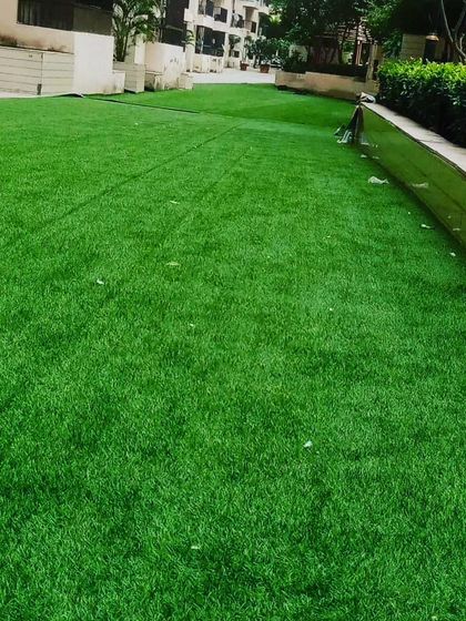 A large artificial lawn in a residential complex common area. It provides a green space for residents without the high cost of maintaining a real lawn.