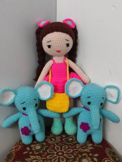 This doll is surrounded by her two elephant friends. They are made with a lovely blue yarn.