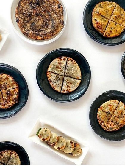 An assortment of our breads, including the flaky chur chur paratha and various stuffed kulchas. Each one is designed to be an integral part of our inventive Indian food philosophy.