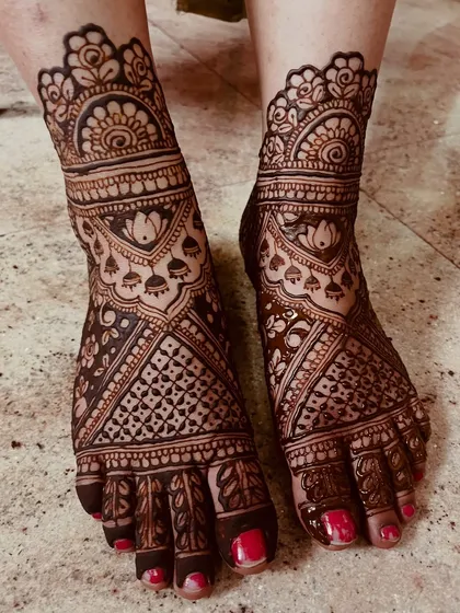 Bridal mehendi isn't complete without adorning the feet. This design features dense, intricate patterns covering the entire foot, with beautiful lotus and jhumka motifs that complement the hand henna perfectly.