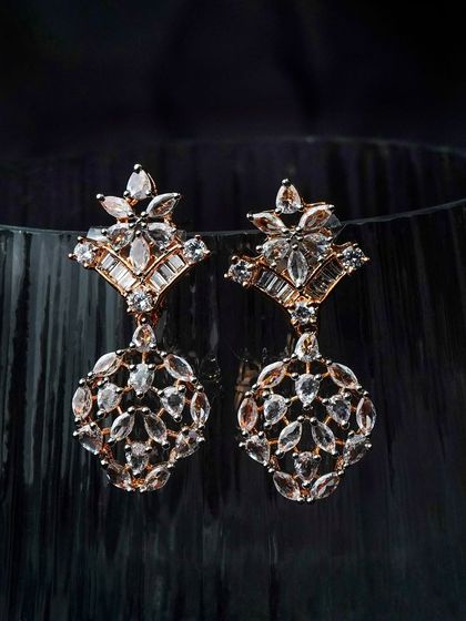 A pair of diamond earrings shot against a dark, reflective surface. This technique adds depth and a sense of luxury, perfect for high-end jewellery photography.
