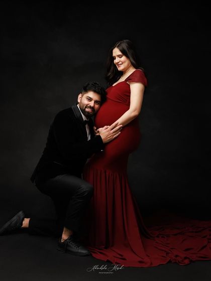 A father-to-be listens to his baby's heartbeat. This classic maternity pose is filled with love, connection, and happy anticipation.