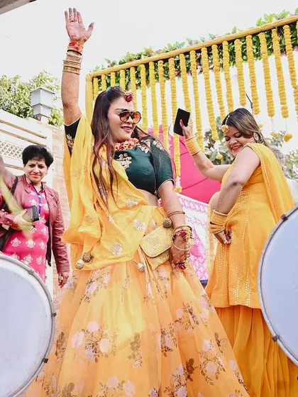 The bride dances with abandon to the beat of the dhol. I focus on capturing the high-energy moments and the vibrant colors of the Haldi ceremony.