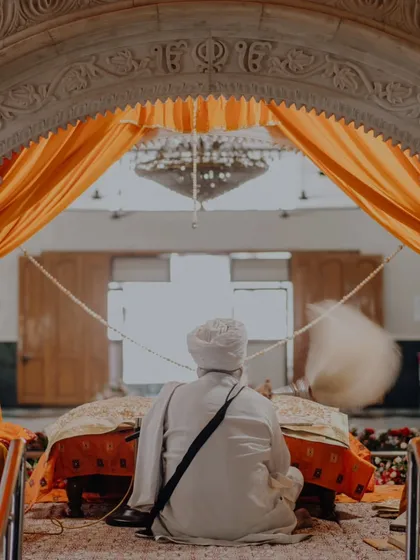 A powerful image from behind the Granthi during a Sikh wedding, capturing the spiritual heart of the ceremony.