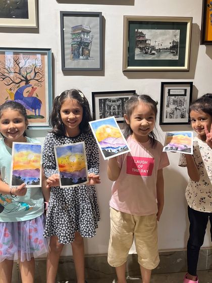 A group of our youngest artists with their sunset watercolor paintings. It's so rewarding to see them learn about color blending and create these lovely scenes.