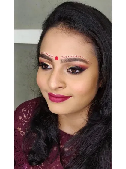 For my beautiful Bengali brides, I specialize in creating the traditional look with intricate Chandan art on the forehead. This is paired with a dramatic smokey eye and a rich magenta lip for timeless elegance.