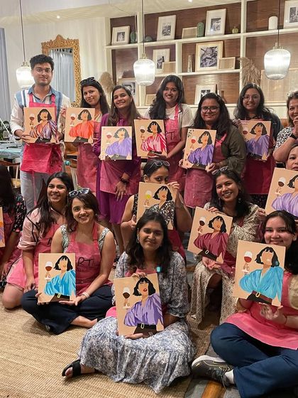 A large and happy group from a sip and paint workshop. It's a fantastic social event for any group of friends.